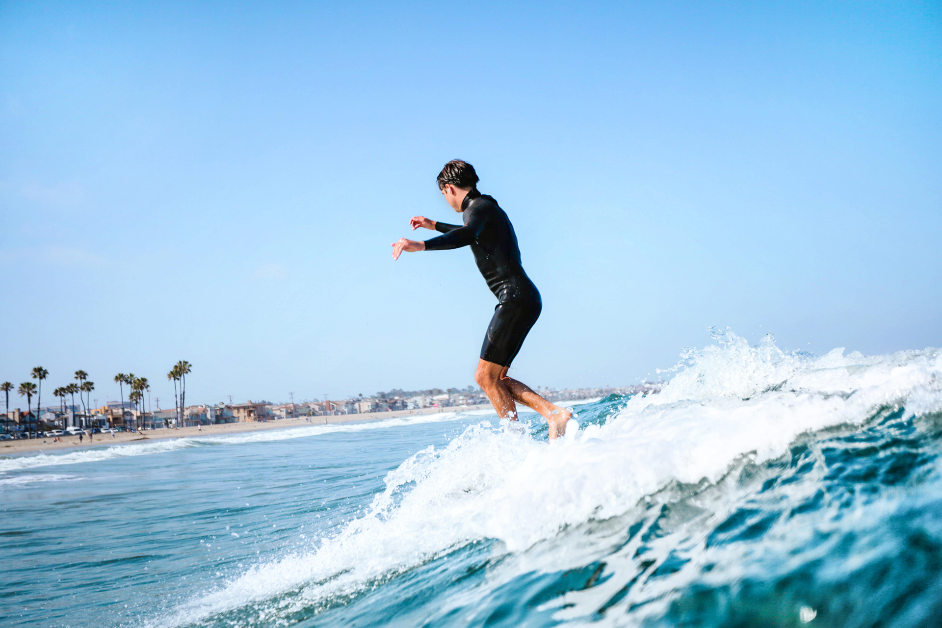 young man surfing in newport beach